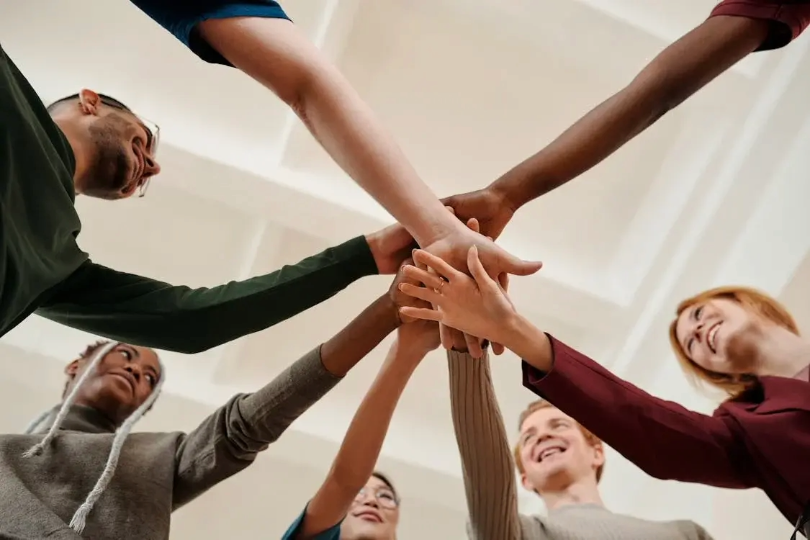 people of different races in a circle looking down at the camera, representing diversity and inclusion in recruitment