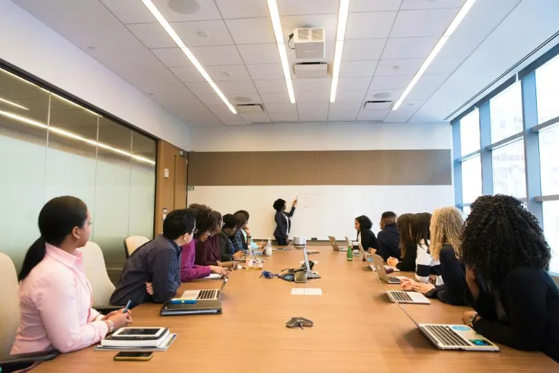 manager at a board explains early career talent strategy to hiring team