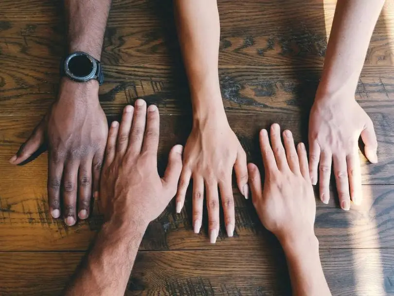 Hands of different races, side by side, aligning with the idea of diversity recruiting metrics