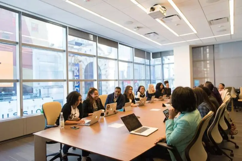 a team of people from different races around a table with laptops, aligning with the idea of diversity recruiting metrics